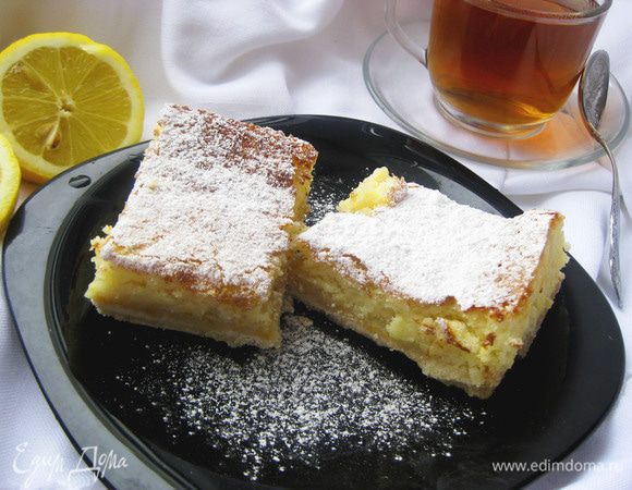 Полностью остужаем в холодильнике, нарезаем на квадраты и посыпаем сверху сахарной пудрой. Готовые пирожные будут немного плохо резаться, прилипать к ножу, но на вкус это никак не повлияет.