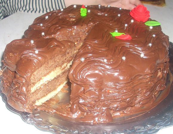 Разогреть духовку до 180 С (середина, конвекция - 160 С).
Растереть сахар с маслом в однородную массу. Добавить яйца, затем смешанные муку и разрыхлитель. Разделить тесто на 2 части: в одну добавить какао и в другую молоко.
Выпекать 4 коржа в выстланной бумагой форме. Каждый корж выпекать по 20 минут.
Сделать крем для украшения. Растопить шоколад на паровой бане (я добавляла небольшой кусочек сливочного масла), снять с огня, остудить. Затем добавить к шоколаду яйца, ванильный сахар и масло. Хорошо перемешать. Поставить в холод на несколько минут.
Промазать коржи сливочным кремом, чередуя темные и светлые. Сверху обмазать шоколадным кремом. Поставить готовый торт в холодильник на 2 часа. Украсить 
