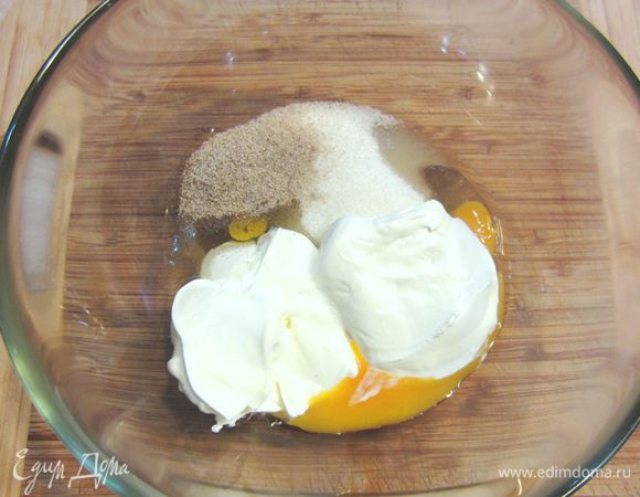 Тем временем сделайте заготовку для крема. Разбейте одно яйцо, добавьте столовую ложку сахара. Положите туда чайную ложку ванильного сиропа или пакет ванильного сахара с натуральной ванилью. Натрите цедру с половины апельсина и положите 120 грамм сметаны (по рецепту Крем-фреша).