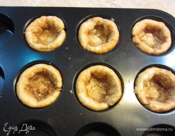 Достаньте форму из духовки. Прижмите чайной ложкой поднявшееся тесто, чтобы ямочка в корзинке стала больше.