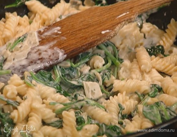 Отправить макароны в сковороду к шпинату с сыром, перемешать и прогревать 1–2 минуты на небольшом огне.
