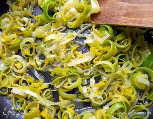 В сковороде разогреть немного оливкового масла. Обжарить на небольшом огне лук-порей (только нежную часть), минуты 3-4, до мягкого состояния. Можно также добавить кусочек сливочного масла - все же оно прекрасно подходит луку. На первой минуте плеснуть вина, на 30-60 секунд увеличить огонь - позволить резкому алкогольному запаху уйти. 