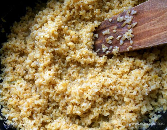 В отдельной или той же сковороде (в этом случае выложить лук и грибы в отдельную посуду) приготовить булгур согласно инструкции. В моем случае: разогреть немного масла, засыпать булгур и перемешать. Залить крупу водой примерно в 1,5 раза превышающей количество булгура, и готовить на среднем огне, помешивая, минут 12-15. Присолить, поперчить. 