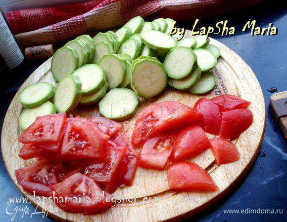 На основании помидоров сделаем небольшой, неглубокий надрез крестом, ошпарим кипятком и тоже снимем шкурку. Нарежем помидоры и кабачок (или цукини) круглешками. Если помидор крупный, то можно нарезать треугольгничками, на четыре части каждый кружок.