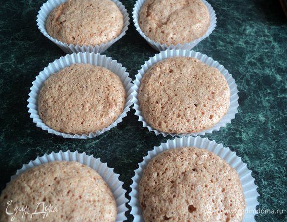 Основу для пирожного из орехового безе осторожно освободить от бумажных формочек, в которых они выпекались и переложить в новые.