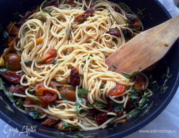 Пасту отварить до состояния al-dente, воду слить (но немного сохранить), выложить пасту в сковороду, плеснув воды. Добавить немного оливкового масла EV (или масла из-под томатов). Перемешать и оставить на минуту, пропитаться ароматами. При подаче оформить оставшейся руколой и рикоттой. 