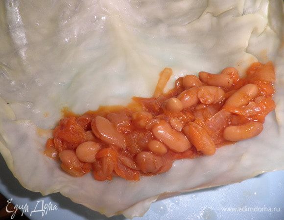 На каждый капустный лист выкладываем начинку и заворачиваем трубочкой.