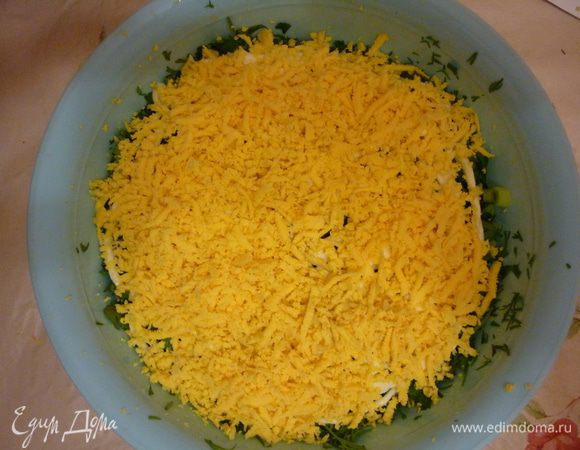 Затем на терку трем яйца  и прижимаеи слой к уже имеющимся. И снова делаем майонезную сеточку чуть щедрее предыдущей.