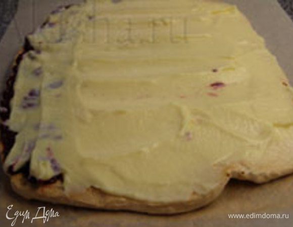 Готовый пласт теста необходимо остудить, снять пекарскую бумагу, нанести крем и ягодную начинку на нижнюю сторону пласта и свернуть рулетом.