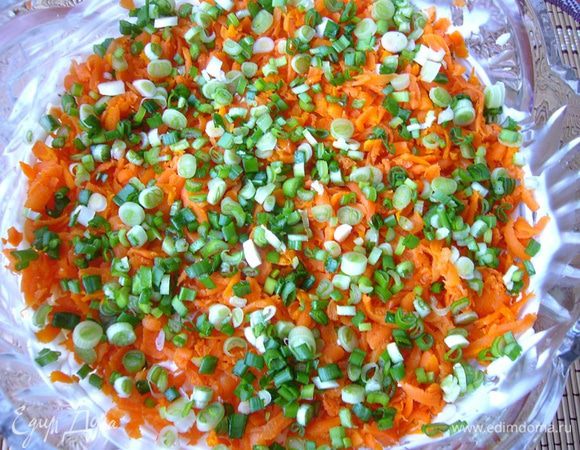 Морковь натираем на тёрке, укладываем на рис. Посыпаем тонко порезанным (вместе с белой частью) зелёным луком.