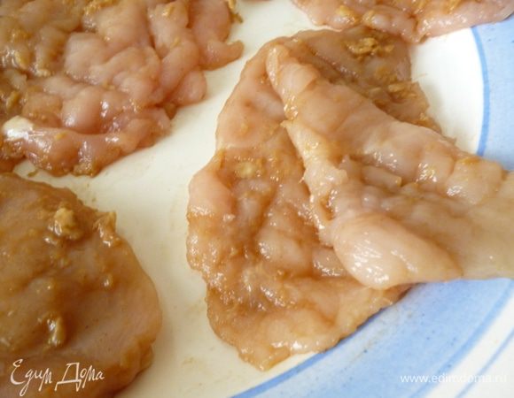 Теперь берем два отбитых филе,сначала смазываем с двух сторон один кусок,на него выкладываем второй и смазываем уже только верхнюю часть.На этом фото я отогнула краешек верхнего филе,что бы было понятней.И так попарно смазываем и соединяем все остальные отбитые кусочки.Накроем крышкой и отправим на 30минут в холодильник.