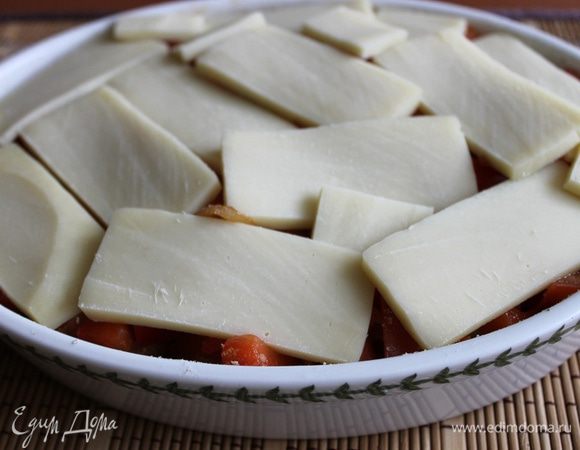 Далее выкладываем овощную смесь. Присыпаем третью панировки.
Моцареллу режем пластиками толщиной 2-3 мм, выкладываем поверх овощей.