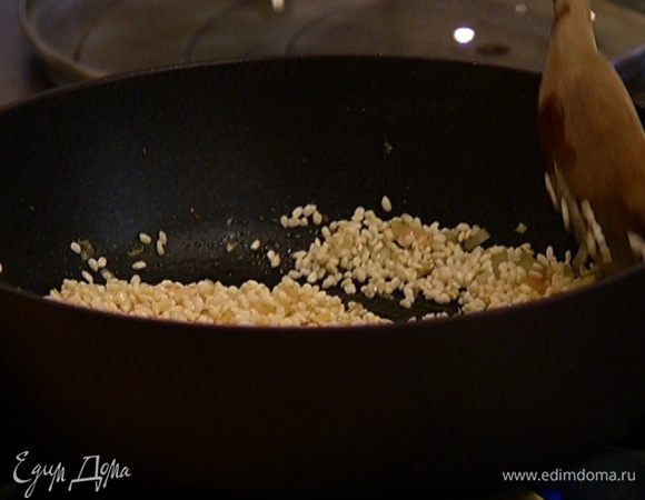 Всыпать рис, перемешать и прогревать 1–2 минуты, чтобы рис впитал часть масла и стал прозрачным.