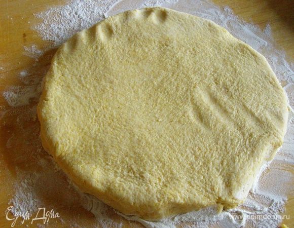 Выложим на разделочную доску, посыпанную мукой. Раскатаем в круг по величине формы