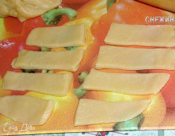 Тесто условно разделим на 4 части. Берем один кусочек теста, раскатываем прямоугольником, не толсто, но и не очень тонко. Разрезаем на полоски, шириной где-то 2,5 см.
