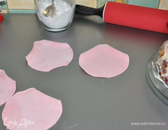 Замесить мастику и раскатать её в тонкий пласт. Вырезать круги для лепестков, края загнуть и оставить подсохнуть. 