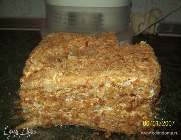 Молоко, желтки яиц, муку, 140 г сахара, ваниль (по вкусу) смешать в холодном виде(не должно быть комков). Эту смесь варить до загустения на водяной бане (н е  д о в о д и т ь  д о  к и п е н и я). Оставшиеся белки (все!) взбить с 50 граммами сахара (отделили от 190 г). Взбитые белки добавить в крем. Перемешать. Коржи ложить друг на друга, обильно смазывая каждый кремом. Обильно смазать кремом верхний корж и бока торта. Весь торт посыпать присыпкой (размятые коржи).