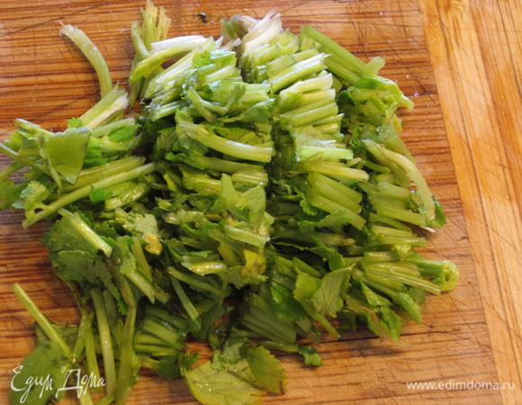 Отрежьте листья кинзы от стеблей. Стебли порежьте довольно крупно. Они отдадут аромат блюду и практически полностью растворятся.