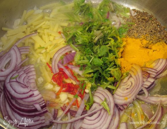 Когда сливочное масло растопится, положите в кастрюлю лук, имбирь, перец чили, семена горчицы и кумина, куркуму, стебли кориандра (кинзы), чеснок.