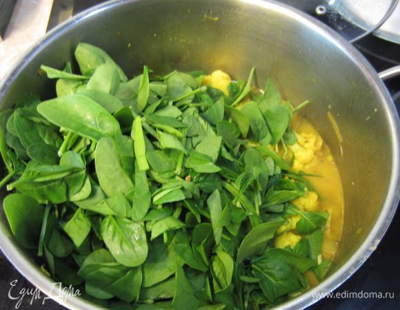 Положите шпинат в кастрюлю и перемешайте.