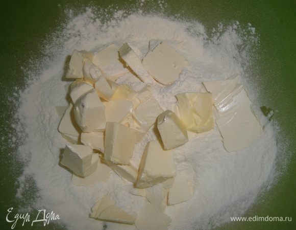 Пока начинка готовится и остывает делаем тесто. В большую миску просеиваем муку, режем в него кусочками очень холодное сливочное масло и растираем руками в крошку. 
