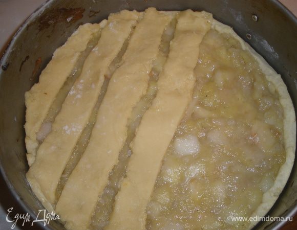 Достаем корж и плотным слоем выкладываем начинку из яблок. 
Нарезаем полоски из второй половины теста и выкладываем их на яблоки на расстоянии в 3-4 мм друг от друга и также накалываем вилкой. Выпекаем еще 40 минут. 