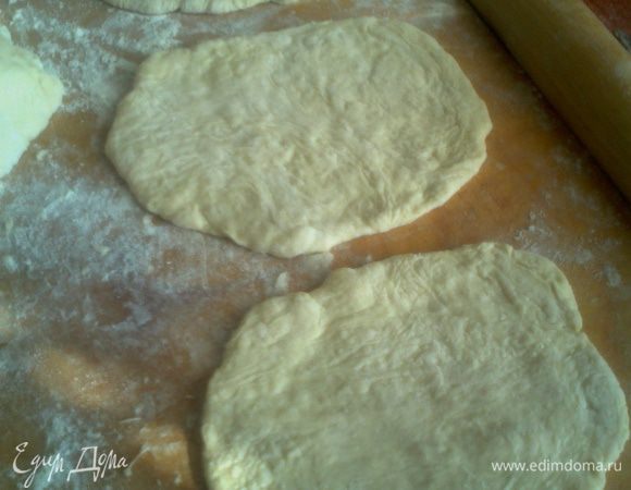 От поднявшегося теста отщипываем по кусочку и раскатываем в лепёшку.