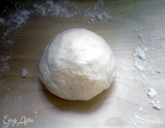 Через 10 минут открыть крышку, посолить муку (соль не должна попадать на воду с дрожжами) и начать замешивать тесто, добавив ещё 60 мл тёплой воды и 2 столовые ложки оливкового масла. Хорошо вымесить тесто. Оно должно выйти гладким и эластичным.