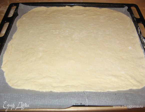 На присыпанной мукой поверхности или непосредственно в форме для пиццы (тогда берите 22-24 см диаметром), смазанной оливковым маслом, раскатать тесто. Если оно очень эластичное, не держит форму и сжимается после раскатывания, дать ему постоять несколько минут и снова раскатать.