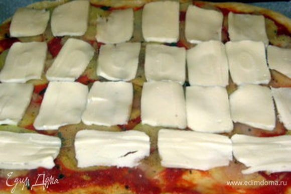 Через 5-7 минут распределить по пицце моццареллу и вернуть в духовку ещё на 5 минут.