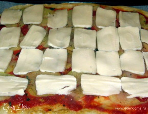 Через 5-7 минут распределить по пицце моццареллу и вернуть в духовку ещё на 5 минут.