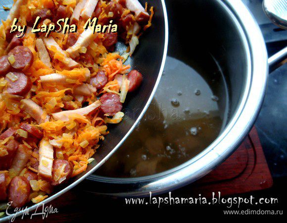 Обжарим на сковороде на растительном масле мелко рубленный лук и тертую морковь. Когда лук станет прозрачным добавим порезанные колечками копченые колбаски и карбонат. Обжарим все вместе помешивая минут 5 и добавим в суп