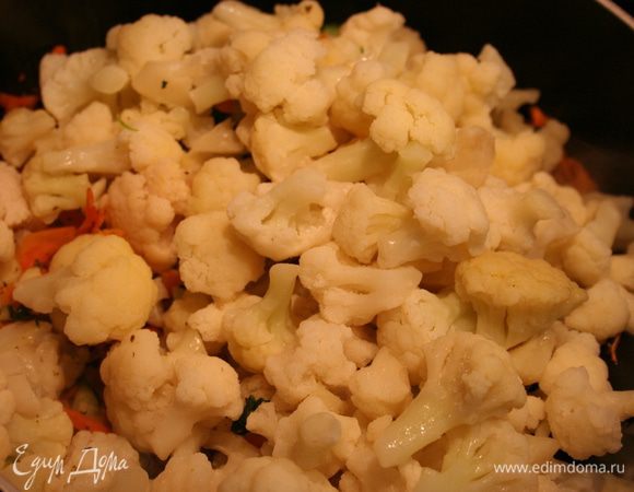 Добавляем кубики сельдерея, он в данном случае будет заменять картофель. Можно добавить еще немного соли. Через 5 минут добавляем цветную капусту. Посыпаем базиликом, орегано, еще немного соли. Все овощи солятся равномерно, поэтому лучше добавлять по чуть-чуть. Тушим под закрытой крышкой. На последнем этапе добавляем зеленый горошек за 5 минут до готовности.  