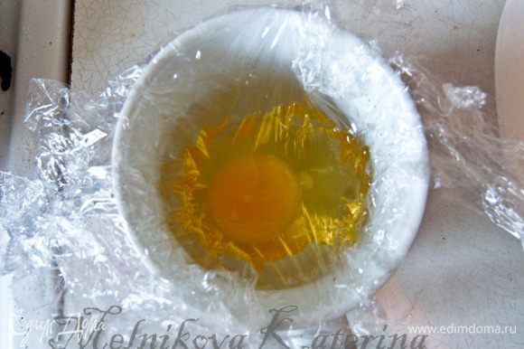 Приготовить яйцо-пашот. Для этого взять довольно большой (примерно 50 см) кусок пищевой пленки. Выстелить ею чашку. Налить 0,5 ст.л. оливкового масла и разбить яйцо.