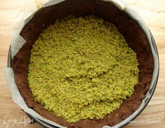 Очищенные от скорлупы и шкурки фисташки (залить кипятком на 10 минут, снять шкурку, подсушить, но не подрумянивать) размолоть в блендере с сахарной пудрой и солью. Выложить фисташковую начинку на чуть охлажденную основу. Хорошо утрамбовать дном стакана! Если не сделать этого, то шоколадная масса может просочиться сквозь орехи.