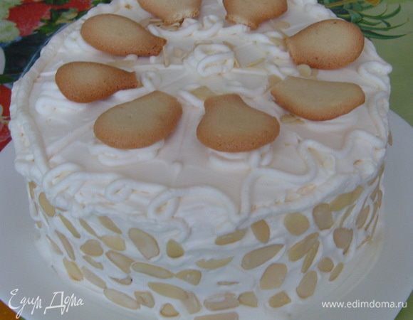 Для украшения взбить сливки. Обмазать торт со всех сторон. Наметить порции торта. Выдавить на каждый кусочек розочки из крема, уложить на них половинки печенья. Украсить края и поверхность торта миндальными хлопьями и полосками апельсиновой цедры.