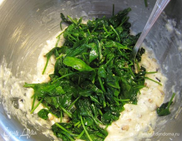 Положите шпинат в миску с начинкой.