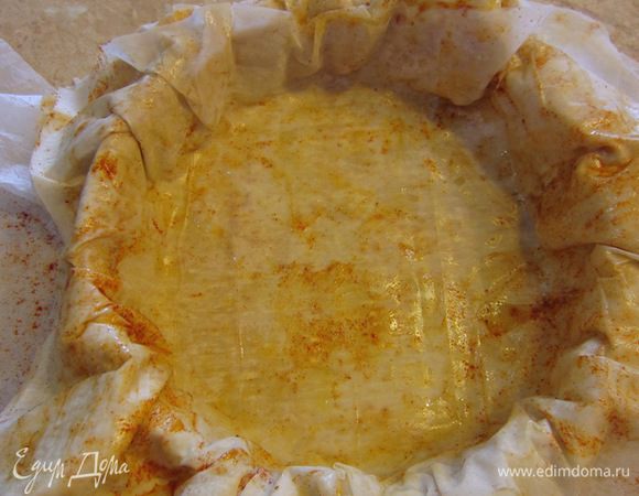 Теперь возьмите подходящую сковороду, чтобы ее можно было потом поместить в духовку (с металлической ручкой). Аккуратно перетащите бумагу вместе с тестом и уложите тесто с бумагой так, чтобы полностью застелить дно.