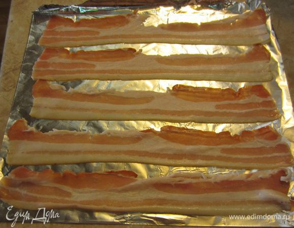 Выложите ломтики бекона на фольгу и высушите их в духовке на решетке в течение пяти минут при температуре 180 градусов. Бекон должен поджариться.