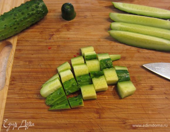 Огурцы порежьте кубиками. Для этого разрежьте его вдоль на четыре части, а затем поперек по 1-2 сантиметра.
