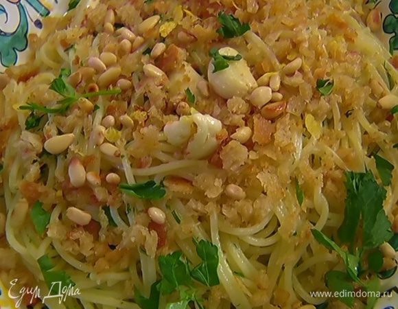 Спагетти выложить в блюдо, посыпать чесночно-хлебной крошкой, кедровыми орехами, лимонной цедрой и оставшейся петрушкой.