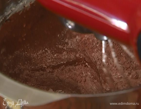 Продолжая вымешивать на небольшой скорости, порциями ввести в тесто муку.