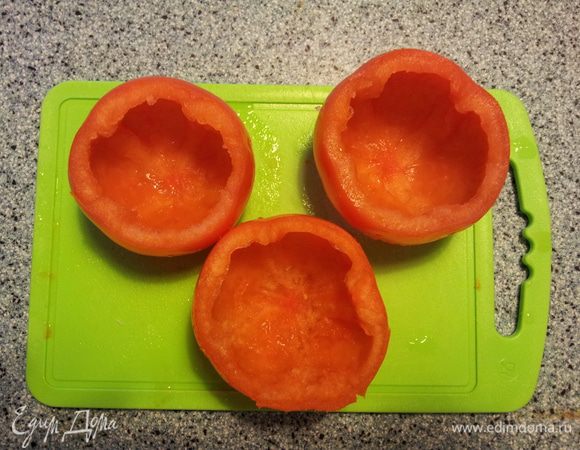 Включить духовку разогреваться 180 градусов. 
Вымыть помидоры и обсушить их. Аккуратно вынуть мякоть. Смазать маслом внутри помидора, посолить, поперчить и вбить яйцо. Поставить в духовку на 25 минут при 180 градусов и на 5 минут при 200 градусов. 