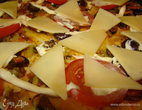 1. Разморозить слоёное тесто, раскатать в половину его толщины. Смазать корж кетчупом. 
2. Спассеровать лук нарезанный кольцами и мидии.
3. Виноградины разрезать на половинки.
4. Сыр нарезать тонкими ломтиками.
5. Помидор нарезать кольцами.
6. Выложить  на корж мидии и лук,виноград, помидор.Посыпать специями.
7. Всё смазать майонезом и выложить ломтики сыра.
8. По вкусу можно добавить свежую петрушку или базилик.
9. Выпекать при температуре 200 градусов. 