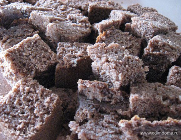 Нижнюю часть коржа срезала толщиной в 0,5 см,это будет основа для торта). 
Оставшийся корж   порезала на квадратики.
