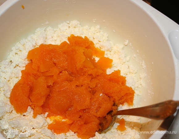 Творог перетереть через сито или хорошо помять вилкой. Добавить тыквенное пюре к творогу. Перемешать, затем добавить взбитые желтки с сахарной пудрой и просеять муку.