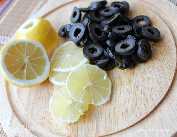 Как только бульон закипел по краям стенок, сразу же уменьшите температуру в духовке до 160°C. Начинается процесс томления. Для большого горшка понадобится примерно 1 час 10 мин. Для порционных — 50 минут достаточно. Примерно за 20 минут до окончания приготовления перемешайте слои, добавьте в солянку лимонный сок. Пока солянка доходит до «кондиции», нарежьте маслины колечками, с лимона срежьте кожицу, нарежьте лимон тонкими кружками. Можно добавить в готовую солянку и каперсы, но мы их не любим.