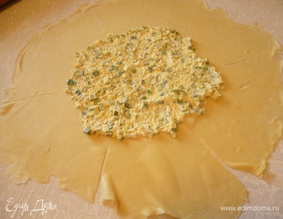 На середину коржа выкладываем 3-4 столовые ложки начинки,оставляя свободные края теста.Затем острым ножом надрезаем тесто на 6 сегментов.