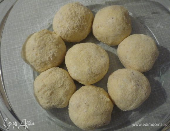 Добавить яйцо, перемешать. Скатать шарики. Я спрятала в каждом по вишенке. Можно сделать с изюмом.
Обвалять в манке, поставить в морозилку (я оставила на ночь).