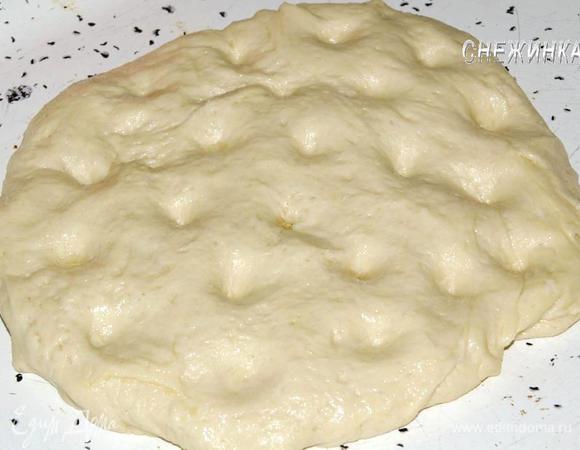 Тесто выложить на противень, сделать пальцами небольшие углубления. Смазать оливковым маслом и оставить на 30 минут.